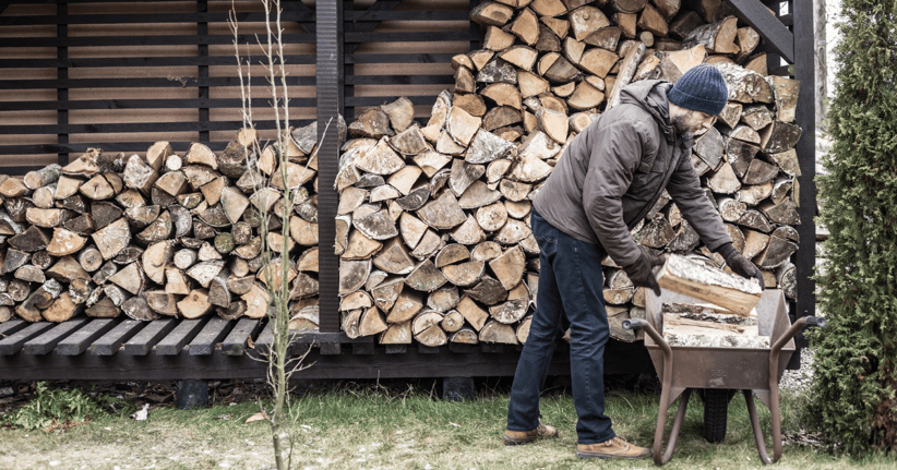 man-loading-wood-into-wheel-barrow